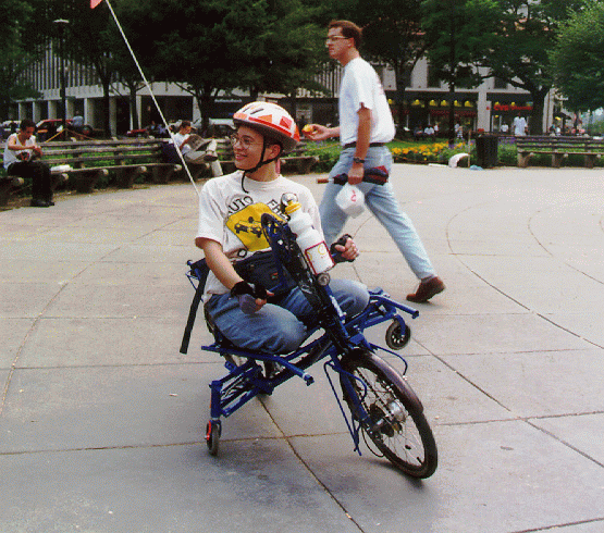 [PHOTO: Jen on handbike, conversing]