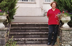 Pam standing on the Dualla House  front stairs